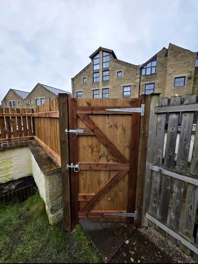 Completed timber access gate with diagonal bracing and metal hardware