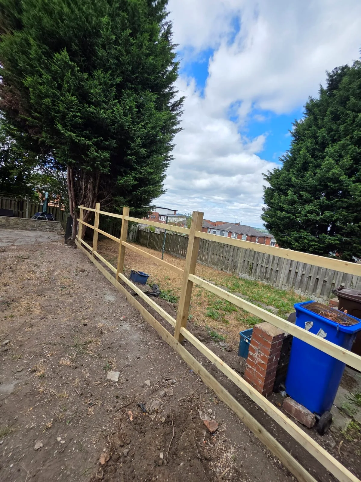 Timber posts and horizontal rails during construction of the boundary fence