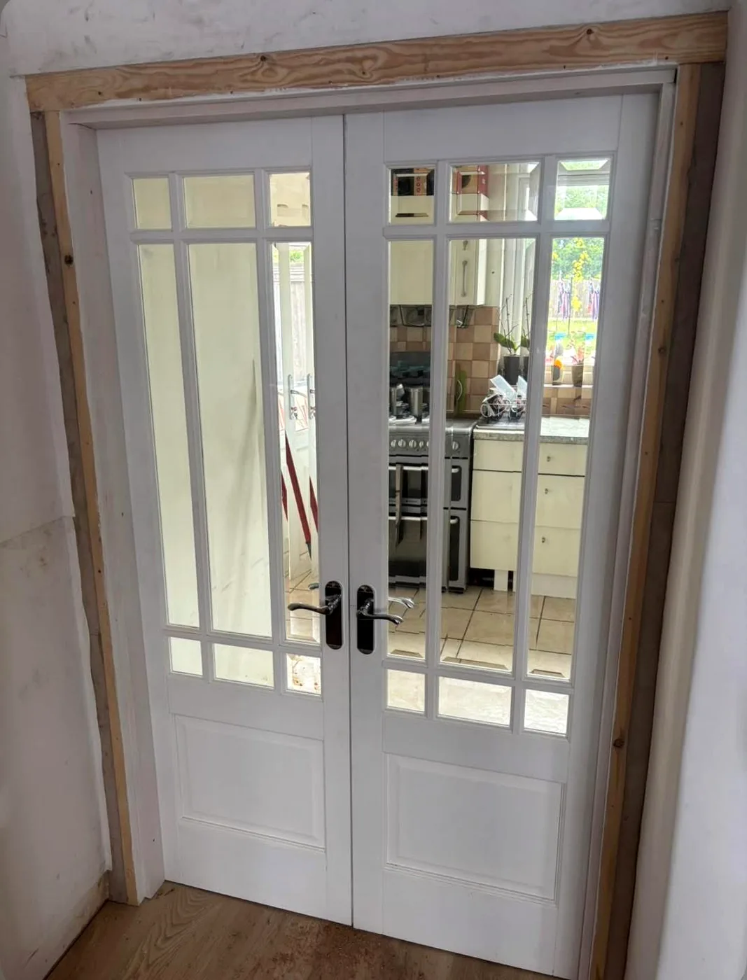 White multi-pane glazed double doors between two rooms