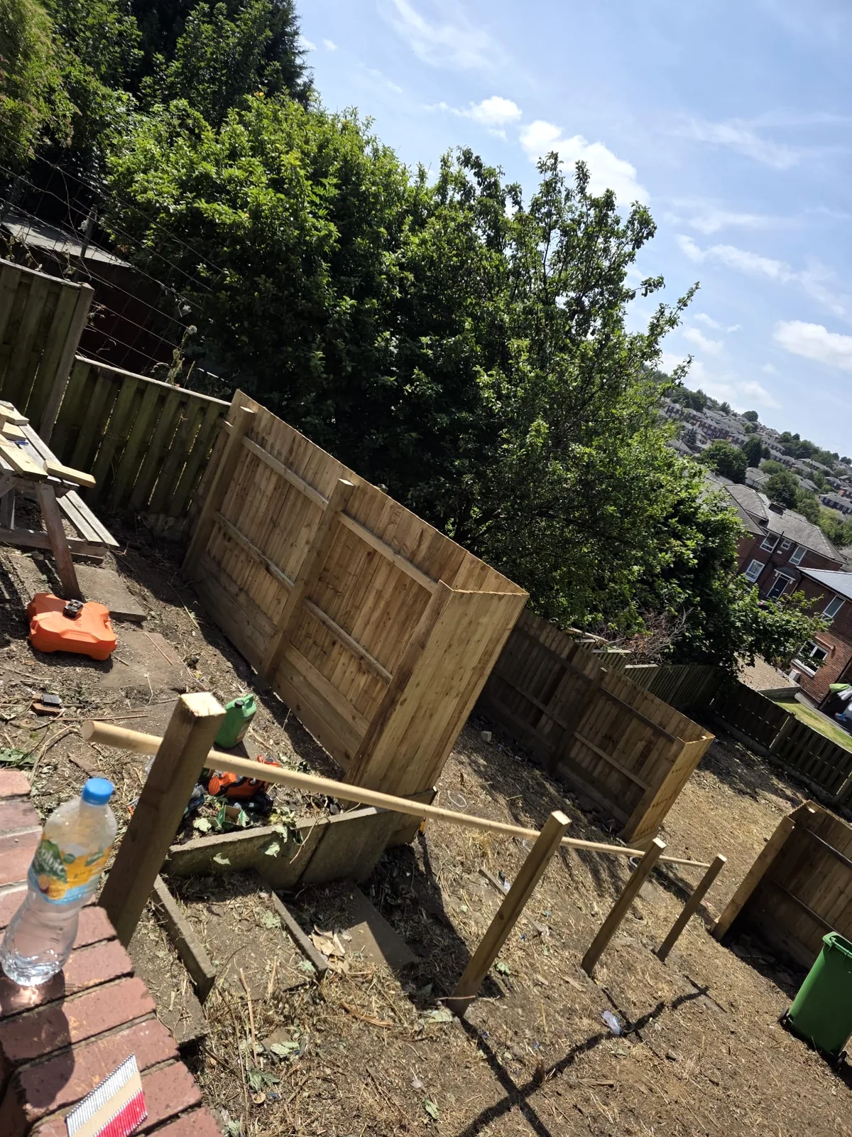 Timber fencing sections during installation on sloping ground