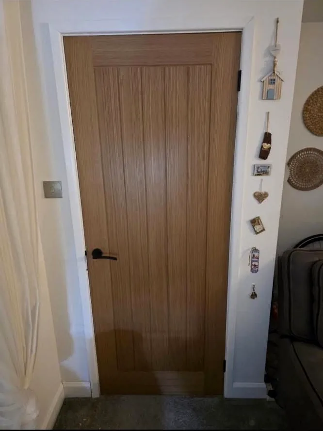 Completed natural oak internal door with black lever handle