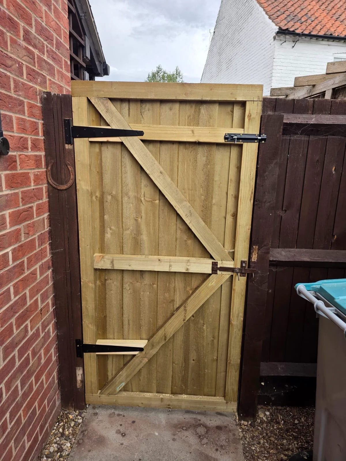 Completed timber garden side gate with black hinges and bolts