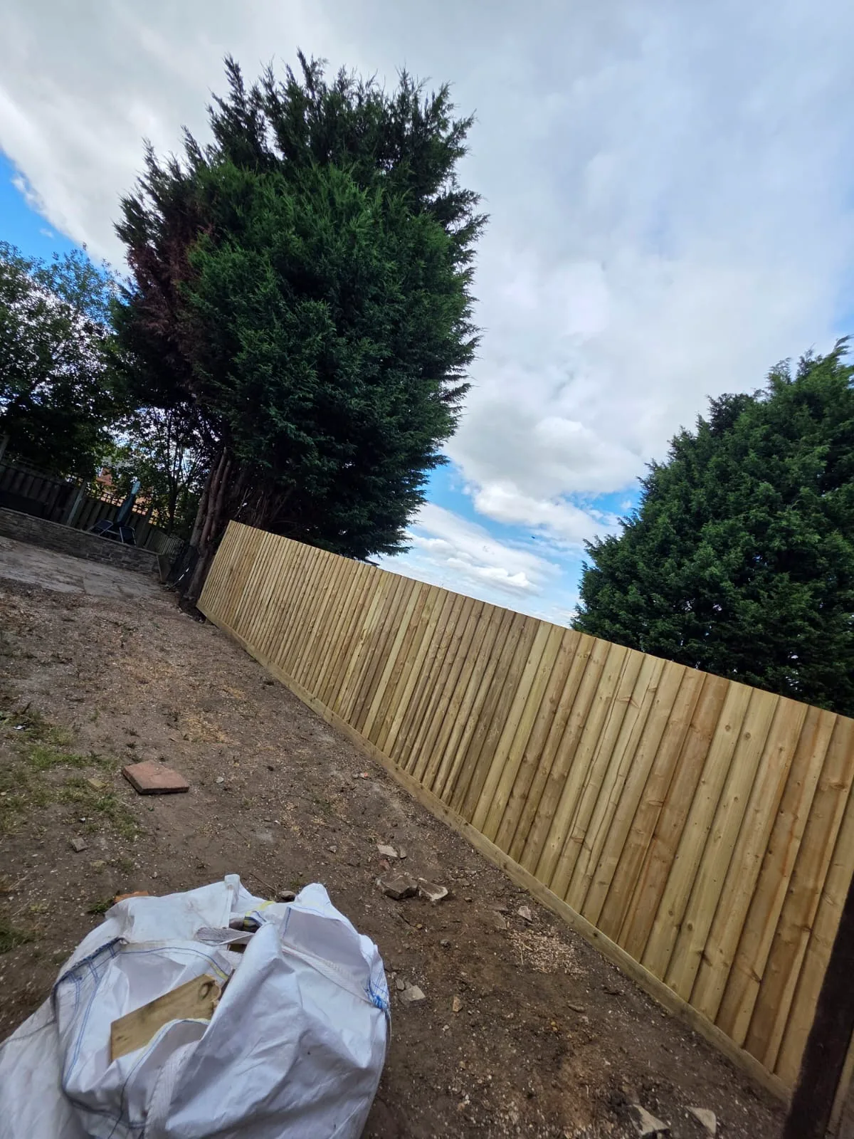 Completed long vertical-board timber boundary fence
